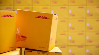 A large DHL cargo box stacked against similar boxes