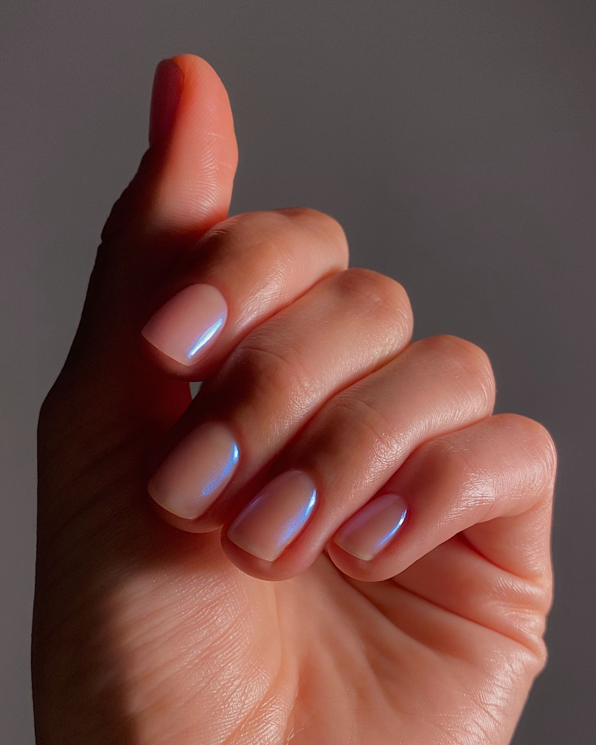A close up of the blue chrome nails on @matejanova with her nails bent in towards her palm