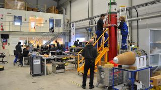Engineers with the MAIUS-1 experiment load payloads onto the sounding rocket.
