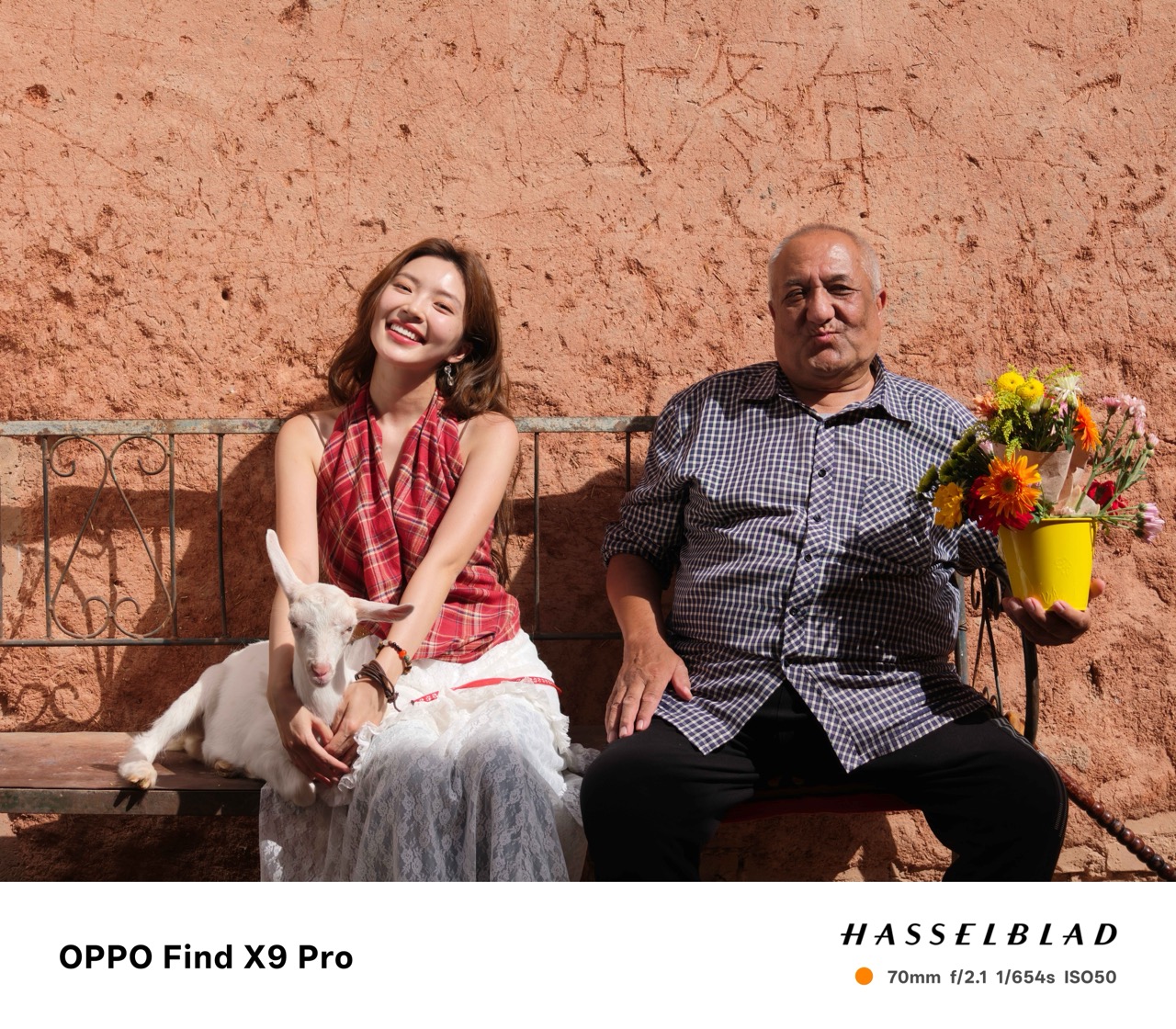 Woman in a red dress sat next to a man holding a pot of flowers taken on an Oppo Find X9 Pro