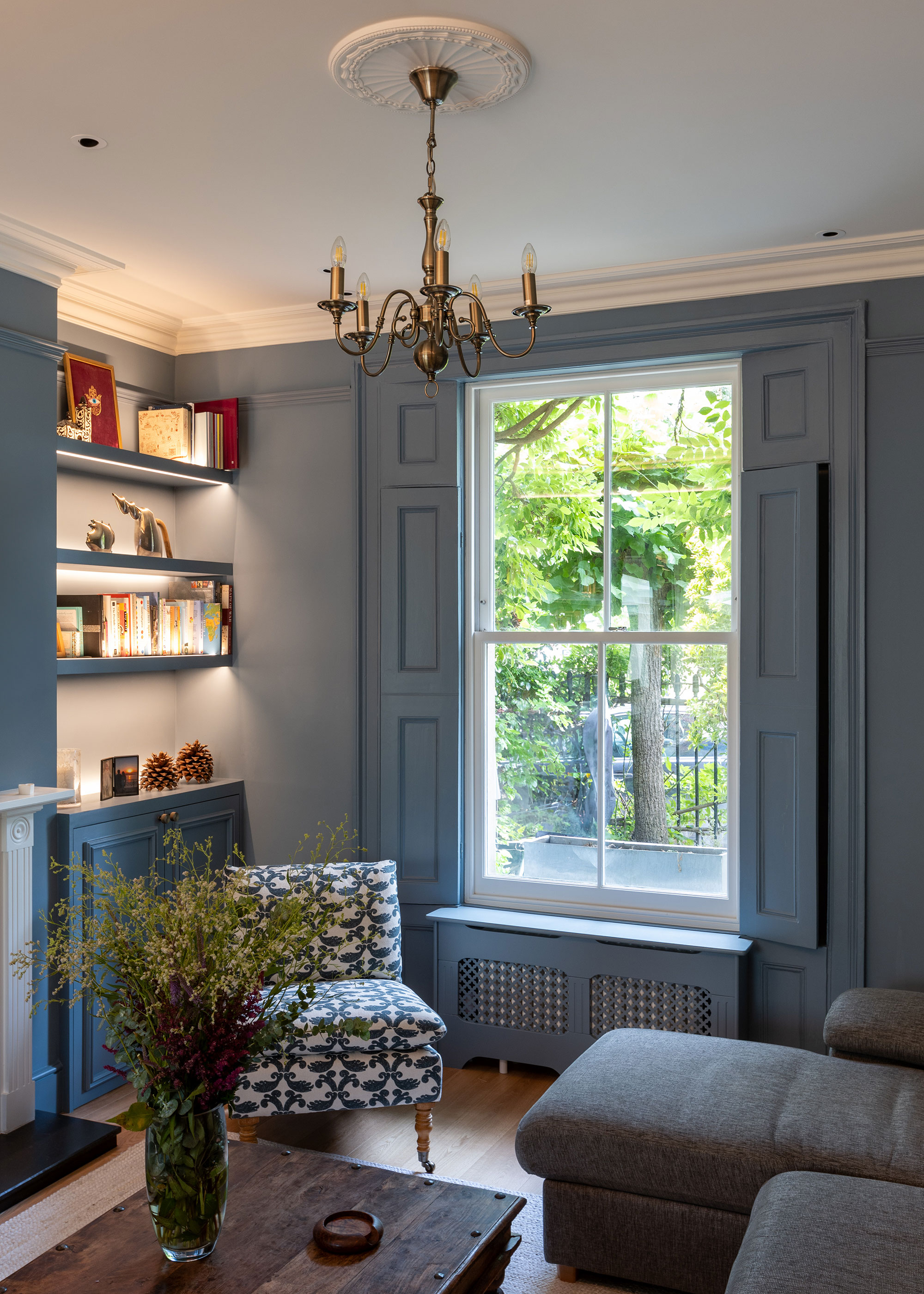 pale blue traditional living room with sash window with shutters
