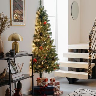 Half christmas tree decorated in lights in white house