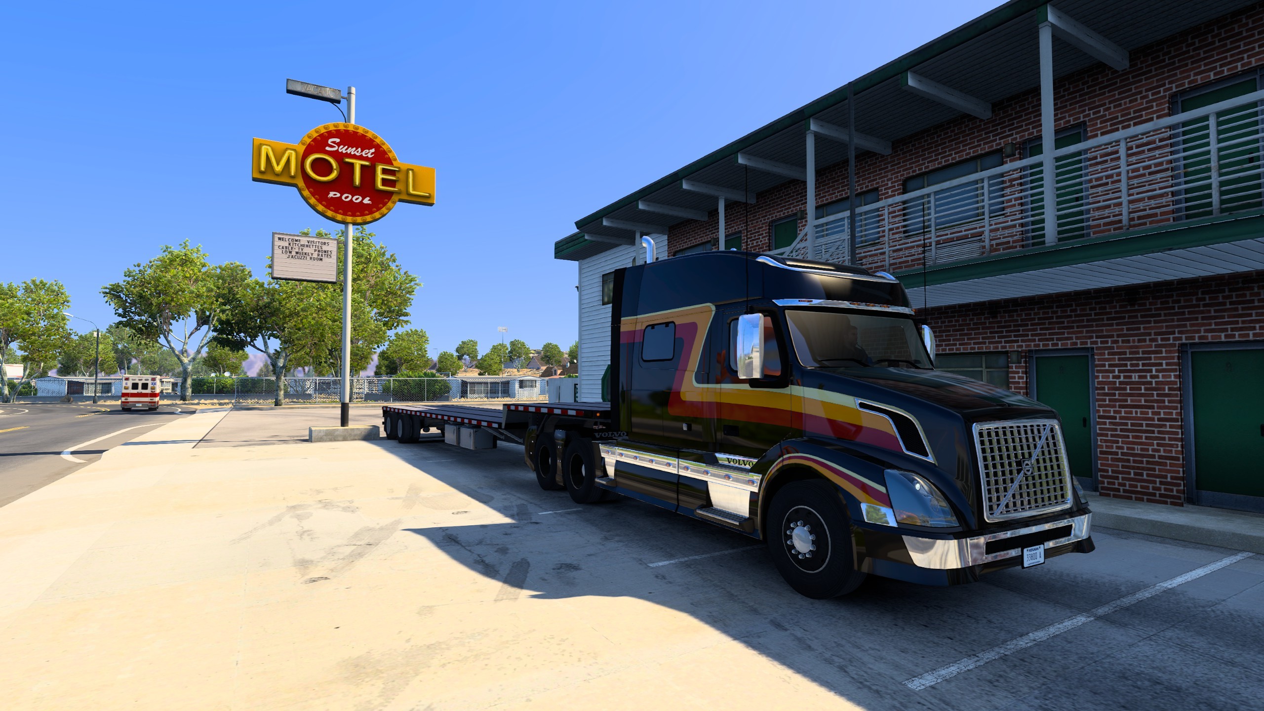 An in-game screenshot from American Truck Simulator of a Black 2014 Volvo VNL 730 parked in front of the Sunset Motel. 