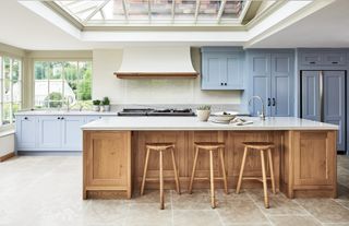 wood kitchen with wood island and blue cabinets