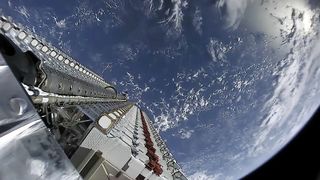 SpaceX Starlink Satellites Waiting To Be Released Into Orbit With the Earth In The Background