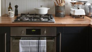 Black kitchen with wooden countertops and oven