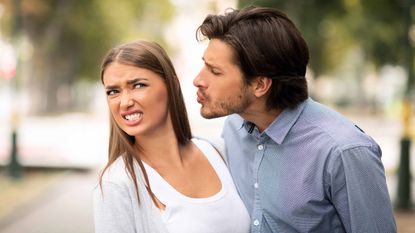 woman avoiding man's kiss