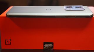 OnePlus 10 Pro sivusta kuvattuna punaisen myyntilaatikon päällä