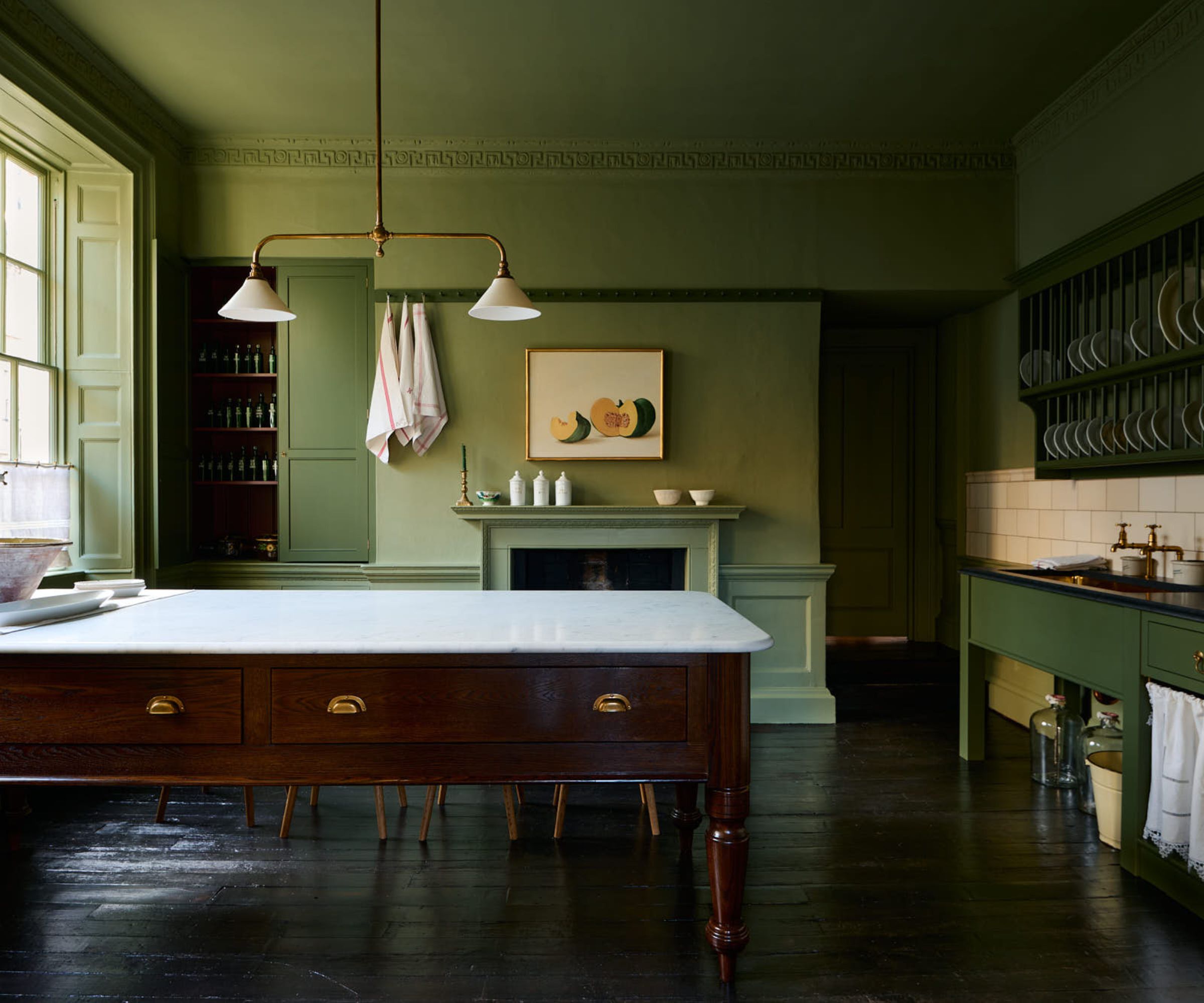 Kitchen color drenched in olive green paint with a burgundy kitchen island