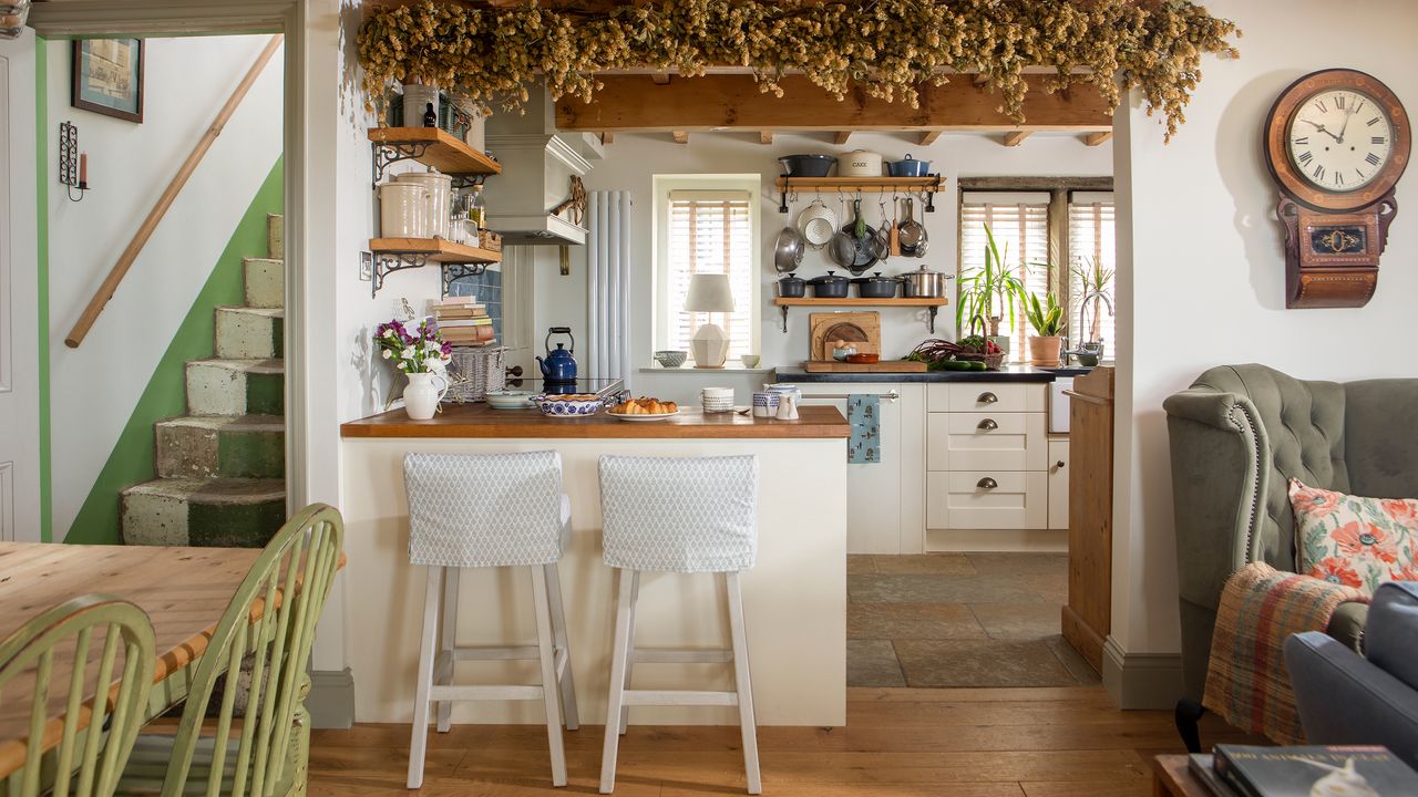 traditional kitchen diner of a cottage with hops hung above breakfast bar