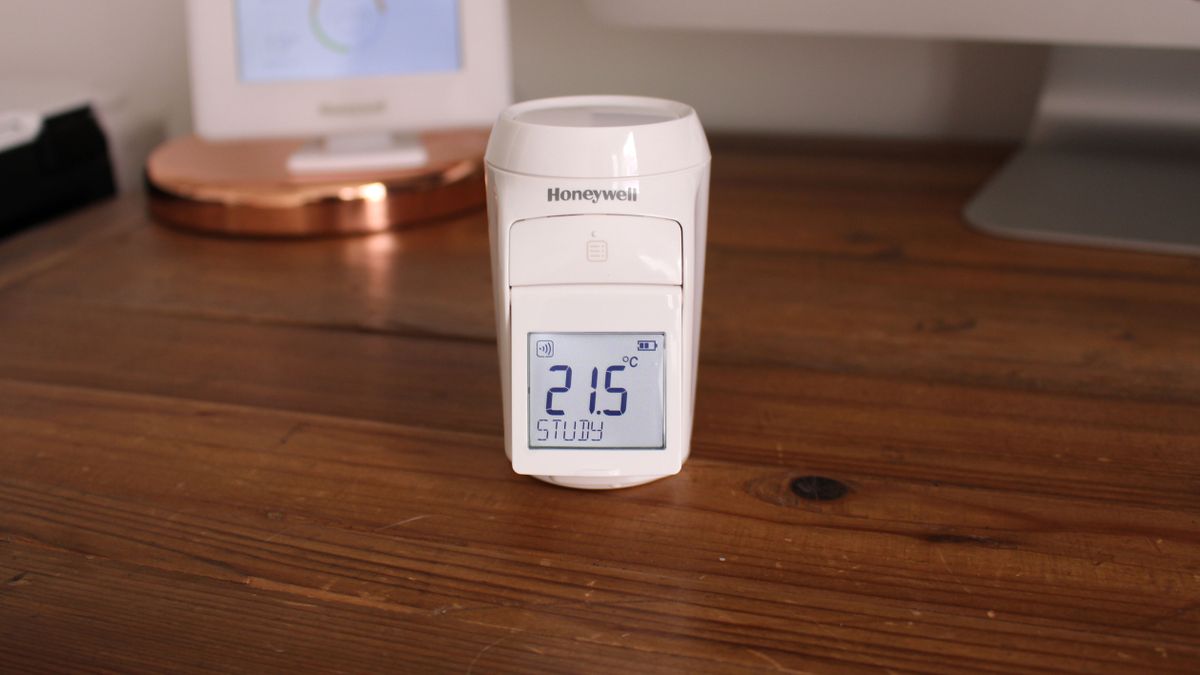Honeywell Evohome smart radiator valve with LCD screen showing current room temperature. The valve is on a table, not attached to a radiator, to show the screen more clearly