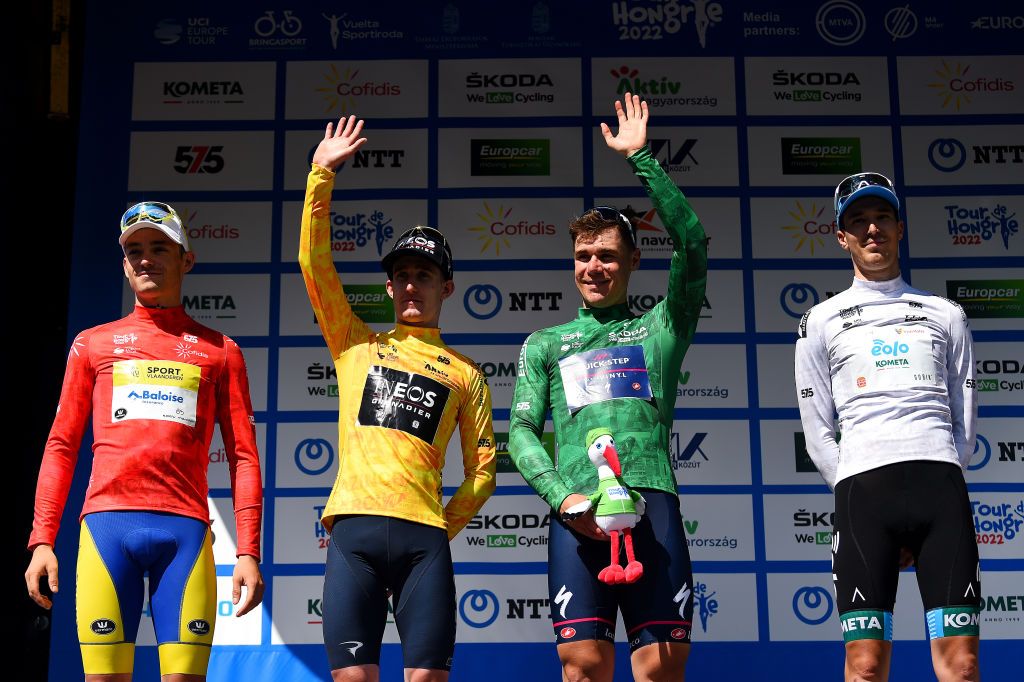 GYNGYSKKESTET HUNGARY MAY 15 LR Aaron Van Poucke of Belgium and Team Sport Vlaanderen Baloise Red Mountain Jersey Eddie Dunbar of Ireland and Team INEOS Grenadiers Yellow Leader Jersey Fabio Jakobsen of Netherlands and Team QuickStep Alpha Vinyl Green Points Jersey and Marton Dina of Hungary and EoloKometa Cycling Team White Best Young Rider Jersey pose on the podium ceremony after the 43rd Tour de Hongrie 2022 Stage 5 a 184km stage from Miskolc to GyngysKkestet 992m tourdehongrie on May 15 2022 in GyngysKkestet Hungary Photo by Dario BelingheriGetty Images