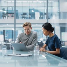  Male and female colleague having a discussion in an office