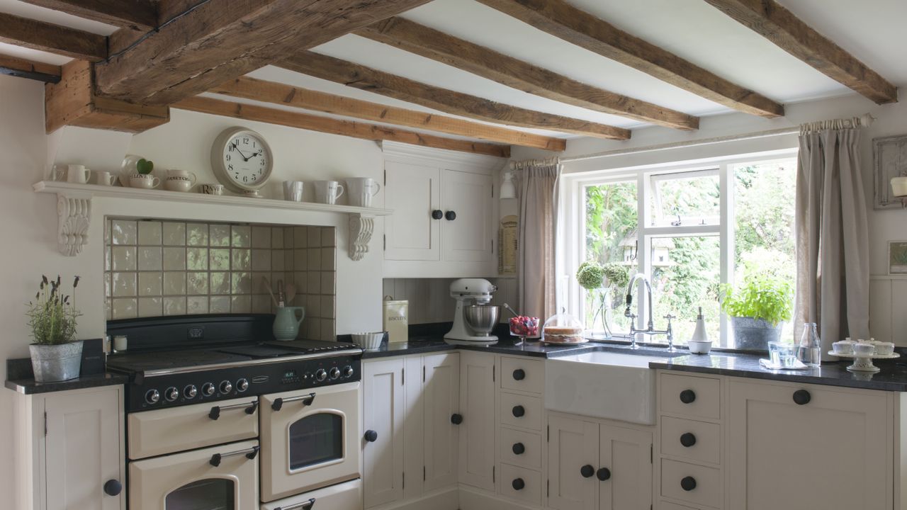 Beamed kitchen with aga, pale walls and units 