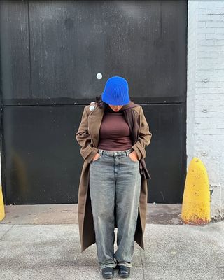 woman wearing cuffed denim outfit with blue bucket hat