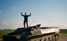 child playing on military vehicle: photograph from a series taken by Ukrainian children