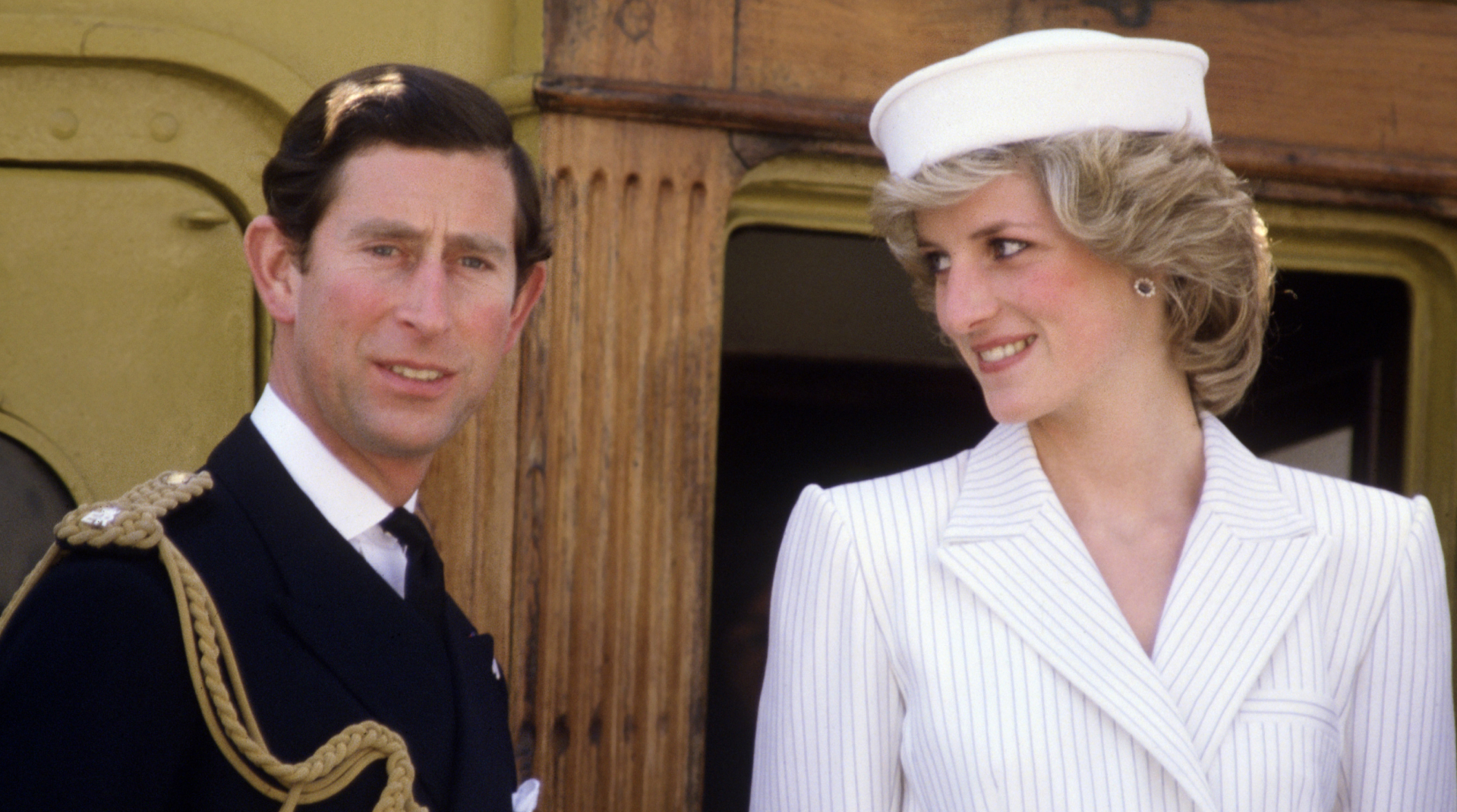 King Charles wears naval uniform and Princess Diana wears a white pinstripe outfit with a matching hat on a boat in La Spezia, Italy, April 20, 1985.