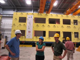 Benjamin Schafer (left), Kara Peterman (center) and structural engineer Rob Madsen (right, in the green shirt) stand in front of their cold-formed steel building and discuss the results of the structure's earthquake test.