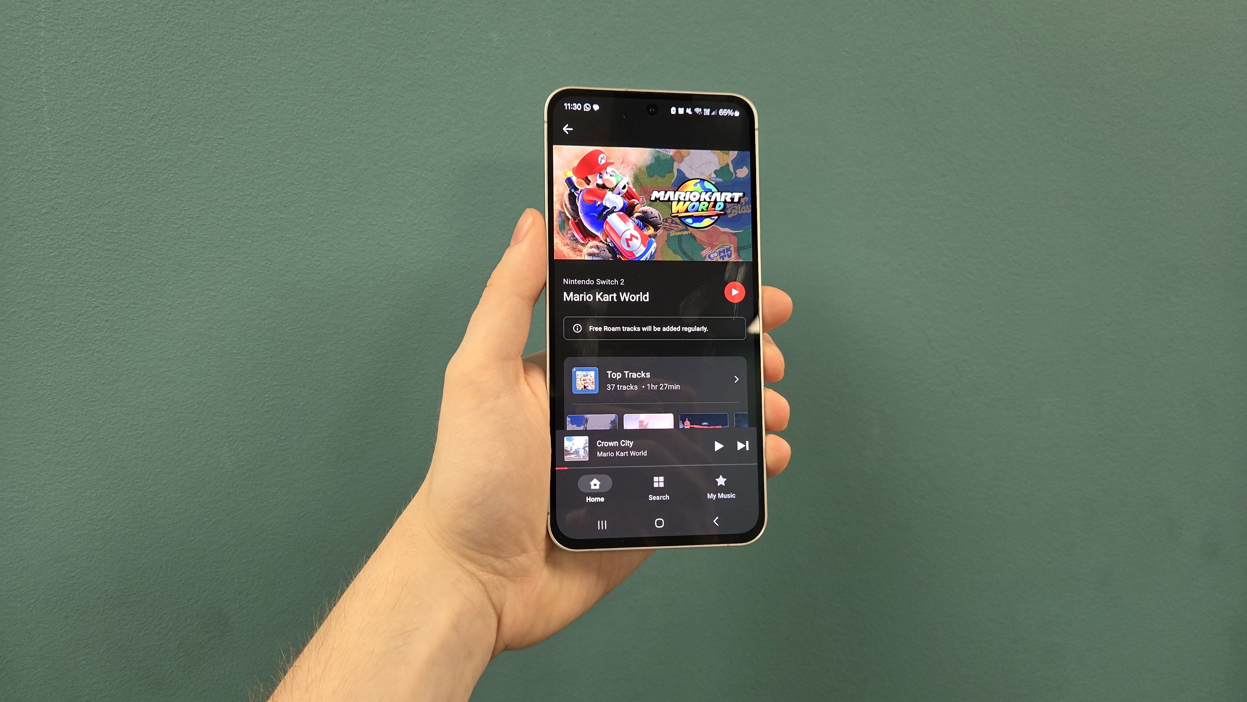Man holding phone with Nintendo Music app on display