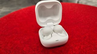 Sony LinkBuds Open earbuds in open charging case on red velvet surface