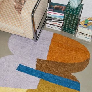 A rug made from a trio of a ovular shapes in purple, orange, brown, blue and yellow