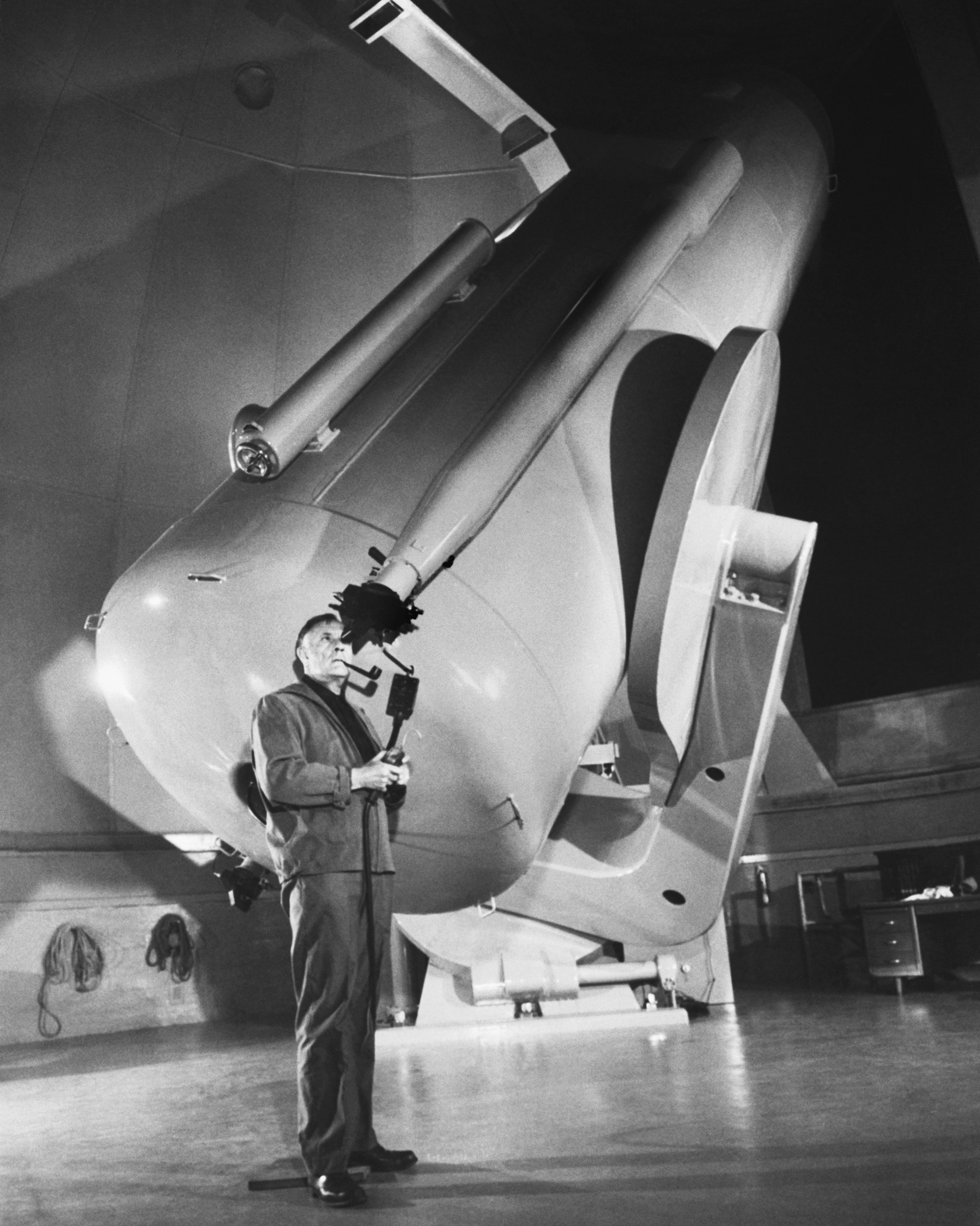 Edwin Hubble looks through a telescope at Palomar Observatory in 1949