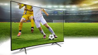 A 4K TV displaying the bodies of two soccer players. The TV is on a soccer pitch in a stadium
