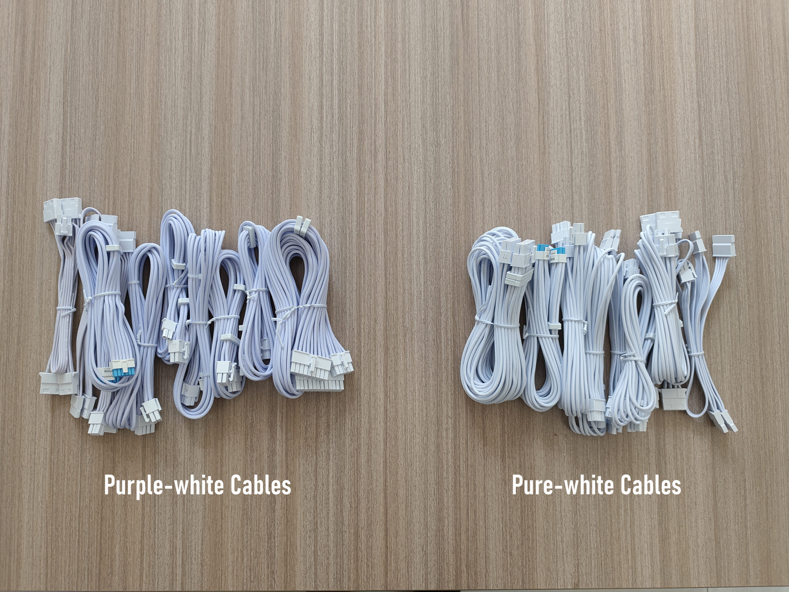 Two bunndles of power cables for the Lian Li SX Platinum Series PSU. The bunndle on the left looks slightly purple and is labelled 'purple-white cables'. The bundle on the right is a cleaner white, and labelled 'pure-white cables'.