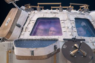 NASA astronauts (from left) Christina Koch, Jessica Meir and Andrew Morgan peer through the International Space Station's "window to the world," the cupola. The trio were on robotics duty monitoring the arrival and capture of the Cygnus space freighter from Northrop Grumman, on Nov. 4, 2019.