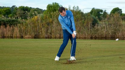 Stop Striking Your Irons Heavy: PGA pro Dan Grieve hitting an iron shot on the 18th hole at Lumine Golf Resort