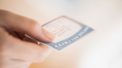 Woman's hand holding Social Security card