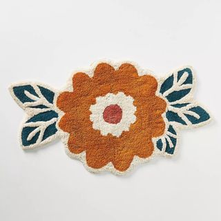 A tufted bath mat in the shape and style of a flower