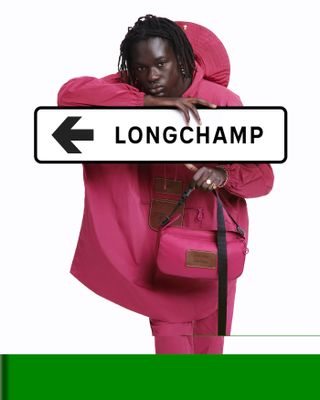 Woman in pink poncho with Longchamp road sign