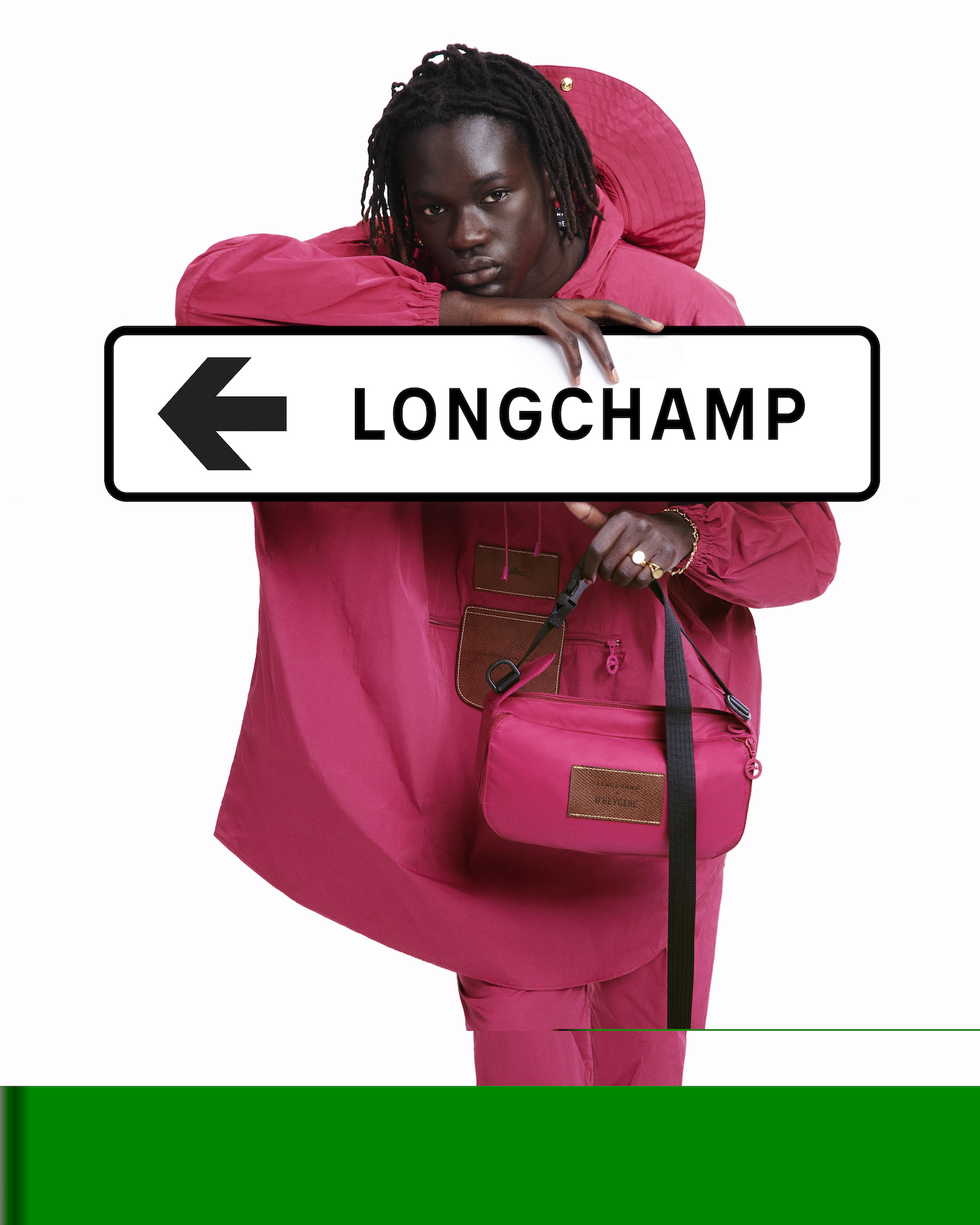 Woman in pink poncho with Longchamp road sign