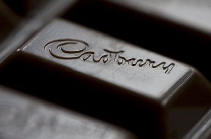 The Cadbury's logo is displayed on a bar of Cadbury's chocolate