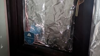 aluminum foil on tom's front window, from the inside