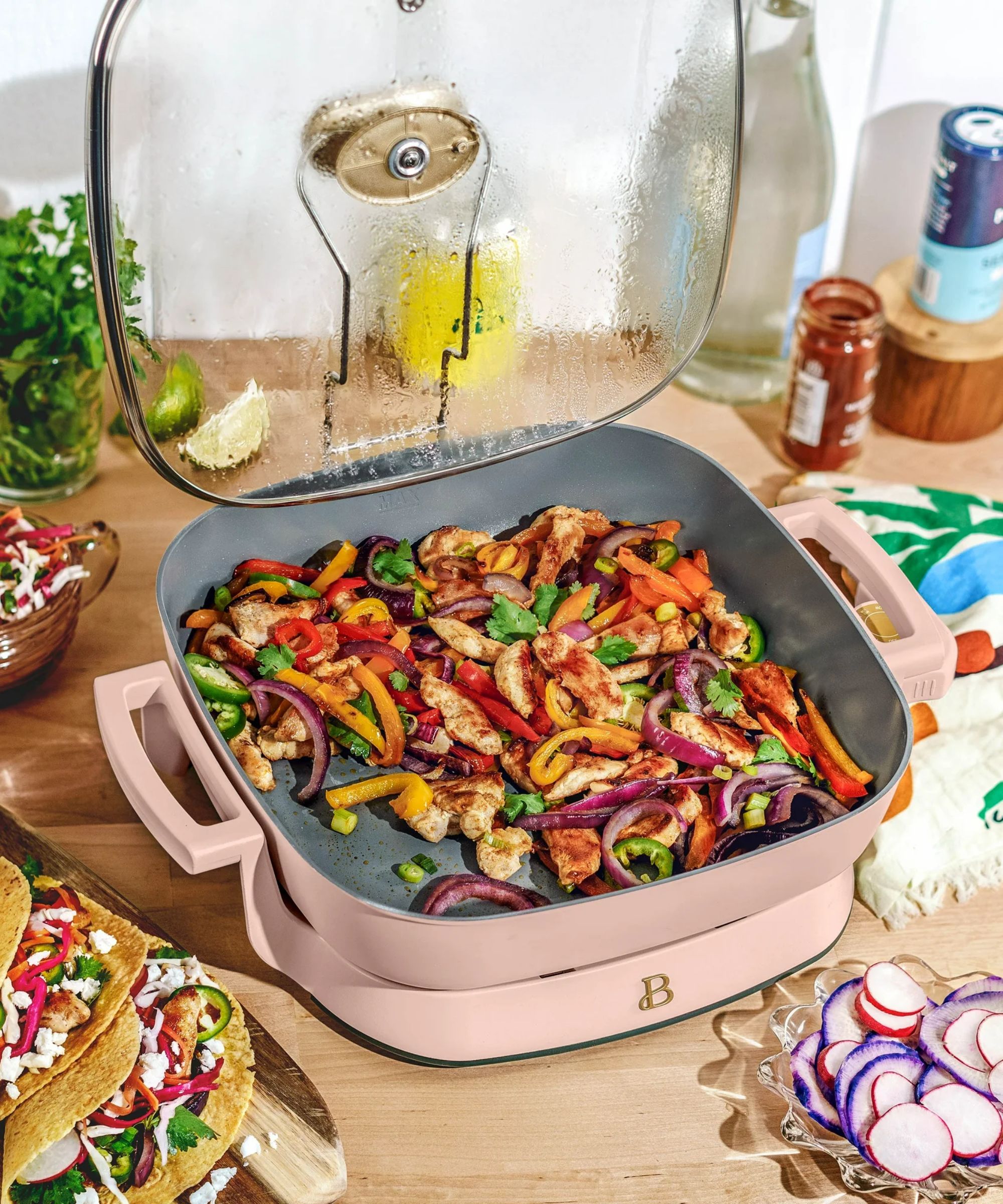 Pale pink electric skillet filled with taco vegetables and chicken