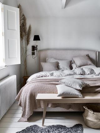 Guest bedroom with white color scheme and linen pink and grey bedding