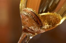 Coins in a glass of sparkling wine