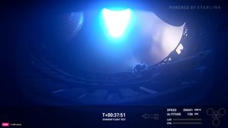 A rocket engine fires up with blue flame on SpaceX Starship Flight 6