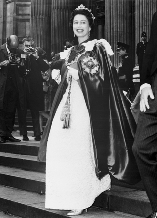 Queen Elizabeth II steps in regal splendor as she leaves St. Paul's Cathedral after attending the 150th Anniversary service of the order of St. Michael and St. George. Her royal highness wore a white embroidered lace gown topped by a blue satin robe bearing the insignia of the order. Her head was crowned with a diamond tiara