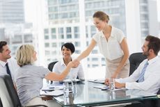 Women shake hands at a business meeting.