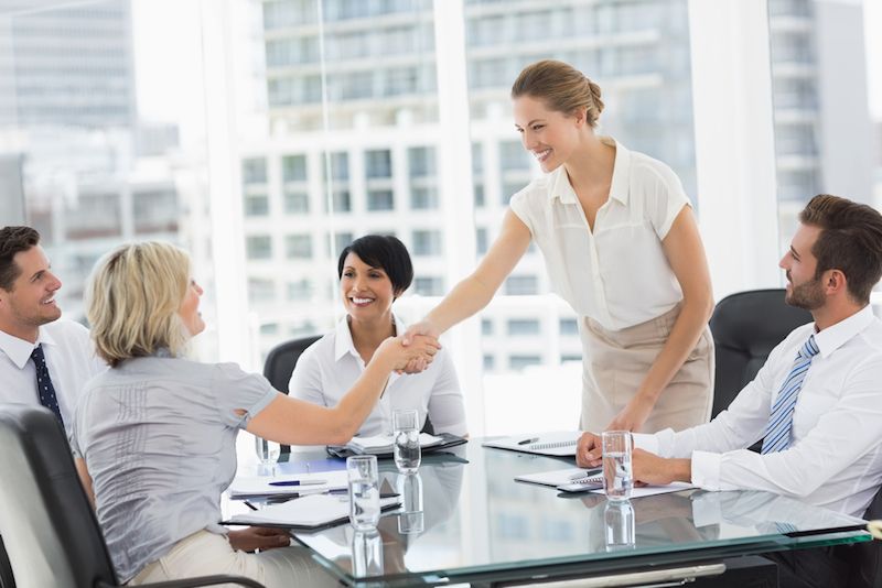 Women shake hands at a business meeting.