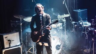 Daniel O'Sullivan from Ulver playing guitar on stage with the band