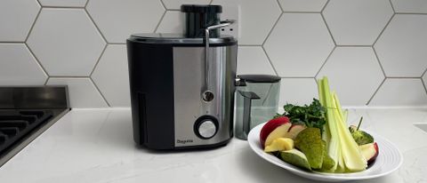 The Bagotte DB-001 juicer next to a bowl of fruit ready to be juiced in the appliance