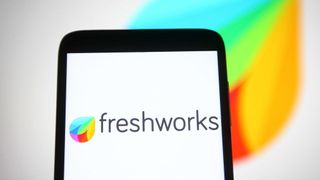 A smartphone with the word Freshworks displayed on screen next to the company logo