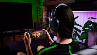 A woman plays a first-person shooter on the Razer Edge