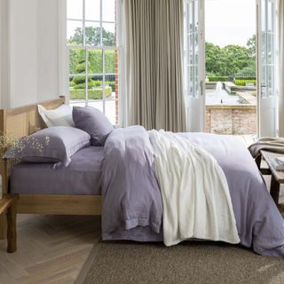 Light purple bedding in a neutral bedroom