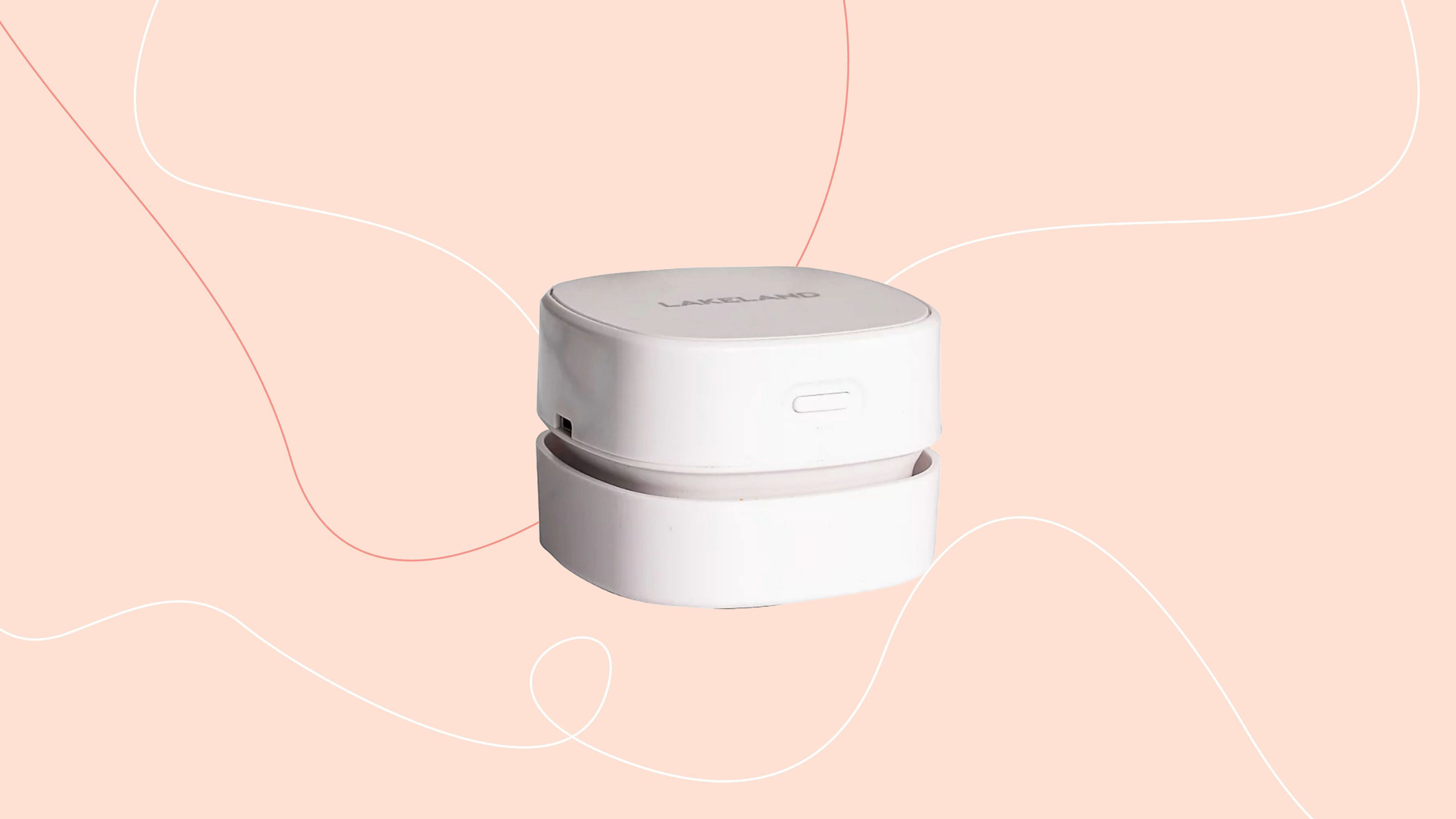 Lakeland mini countertop vacuum on a pink background