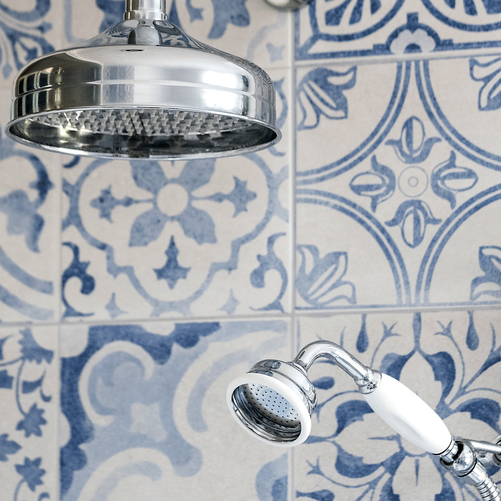 bathroom with blue designed tile wall with overhead and hand shower